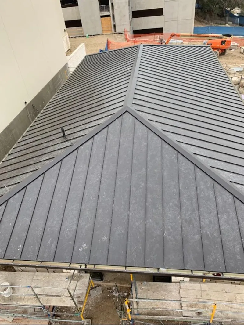 Commercial metal roof construction with crane equipment in Los Angeles